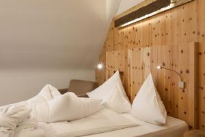 ein Schlafzimmer mit einem Bett mit weißen Kissen in der Unterkunft Hotel Madatsch in Trafoi