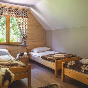 a bedroom with two beds and a window at Ostoja Gorce in Nowy Targ