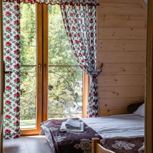 a bedroom with a bed and a large window at Ostoja Gorce in Nowy Targ