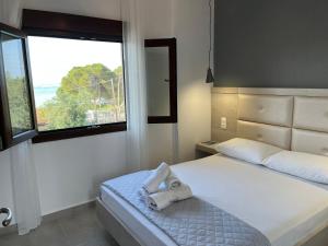 a bedroom with a bed with a large window at Apartment & Studios Haido in Vourvourou