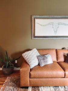 a living room with a brown couch with pillows on it at Rustic Chic - Boutique Luxe Stay Near Broadway in Nashville