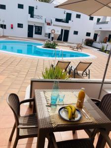 a table with a plate of bananas on it next to a pool at Apartamento Aqua Clara in Puerto del Carmen