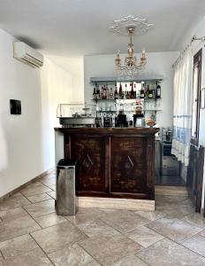 a kitchen with a bar with a chandelier at Hotel Sa Suergia in Villasimius