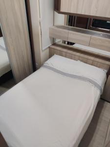 a bed in a small room with a tv at Belo Exclusivo AP Com Garagem na Cidade Baixa Próximo a Santa Casa, UFRGS e Centro Histórico - BnB Serviços Inteligentes Por Fioravante in Porto Alegre