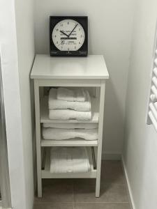 a clock sitting on top of a shelf with towels at L'HEURE BLEUE, magnifique 2 pièces neuf centre historique in Grasse