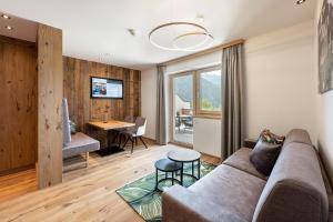 ein Wohnzimmer mit einem Sofa und einem Tisch in der Unterkunft Hotel AlpenSchlössl in Söll