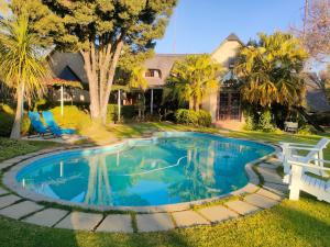 ein Swimmingpool im Garten eines Hauses in der Unterkunft Lipizzaner Lodge - Kyalami, Midrand in Kyalami