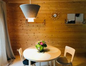 a table and chairs with a vase of flowers on it at Villa Keyritty - Near Tahko Ski/Holiday Resort in Kuopio
