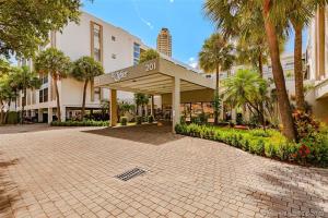 a building with a pavilion in a courtyard with palm trees at Amazing condo 5 minute walk to the beach! in Miami Beach