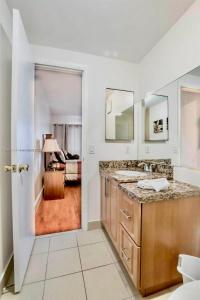 La salle de bains est pourvue d'un lavabo et d'un miroir. dans l'établissement Amazing condo 5 minute walk to the beach!, à Miami Beach
