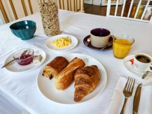 einen Tisch mit einem Teller Gebäck und Tassen Kaffee in der Unterkunft Château de Moliens in Moliens