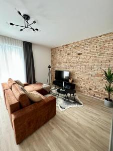 sala de estar con sofá y pared de ladrillo en Cityscape Apartment ~ AC/Indoor parking/Balcony en Budapest