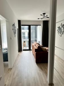 uma sala de estar com um sofá e uma grande janela em Cityscape Apartment ~ AC/Indoor parking/Balcony em Budapeste