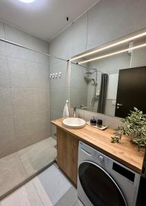 a bathroom with a sink and a washing machine at Cityscape Apartment ~ AC/Indoor parking/Balcony in Budapest