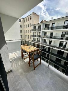 balcón con mesa de madera y banco en Cityscape Apartment ~ AC/Indoor parking/Balcony, en Budapest