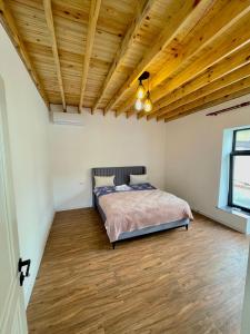 a bedroom with a bed and a wooden ceiling at EMIREST Barnhouse in Gabala