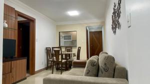 a living room with a couch and a dining room at Luxuoso a 250 Mts da Praia in Guarapari