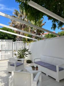 サンタ・マリア・デル・フォカッロにあるVilla Aripèの白い家具と白いフェンスが備わるパティオ