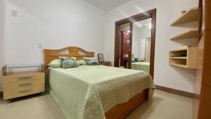 um quarto com uma cama, uma cómoda e um espelho em Luxuoso a 250 Mts da Praia em Guarapari