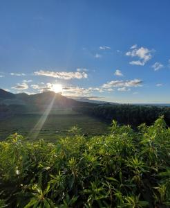 a view of the sun shining on a mountain at Quinta do Sossego-Giestas in Ribeira Grande