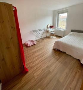 a bedroom with a bed and a wooden floor at Coockooning Led in Basse-Yutz