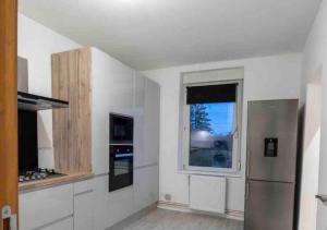 a kitchen with a stainless steel refrigerator and a window at Coockooning Led in Basse-Yutz