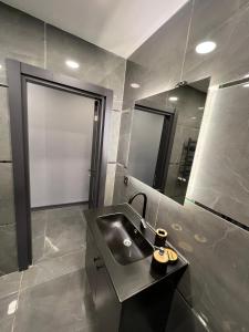 ein Bad mit einem Waschbecken und einem Spiegel in der Unterkunft İstanbul Nişantasi Vip Residance in Istanbul