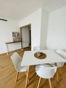 a white dining room with a white table and chairs at Appartement bohème in Manosque