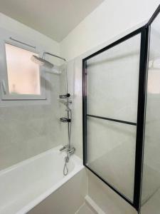 a shower with a glass door in a bathroom at Appartement bohème in Manosque