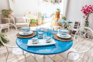 a blue table with plates and cups on it in a living room at IL CORTILETTO in Porto Cesareo