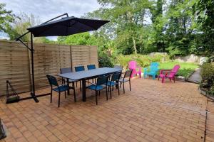 Un patio con una mesa y sillas y una sombrilla. en Appartement dans Maison de ville - 4 personnes, en Oloron-Sainte-Marie 11 fotos más