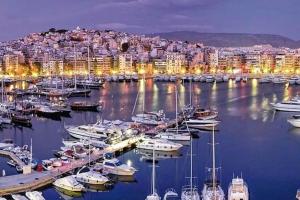 um porto com barcos e uma cidade à noite em Marina Zeas Hidden Gem em Piraeus