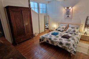 een slaapkamer met een bed en een houten vloer bij Appartement dans Maison de ville - 4 personnes in Oloron-Sainte-Marie