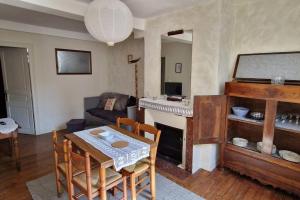 een woonkamer met een tafel en een open haard bij Appartement dans Maison de ville - 4 personnes in Oloron-Sainte-Marie