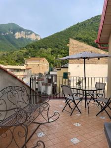 un patio con mesa, sillas y sombrilla en B&B Ai Cortili en Sant'Egidio del Monte Albino