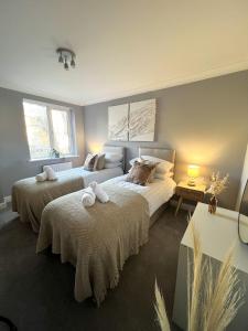 two beds in a bedroom with two windows at Reading City Centre - Free Parking - Franklin Suite in Reading