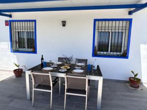 ein Esszimmer mit einem Tisch und 2 Stühlen sowie einem Tisch und einem Stuhl in der Unterkunft Finca rústica “Puerta Palo” in Alozaina