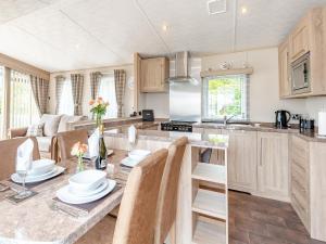 a kitchen and living room with a table and chairs at Tradmach Lodge in Patrington
