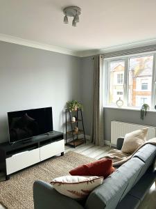 a living room with a couch and a flat screen tv at Reading City Centre - Free Parking - Franklin Suite in Reading