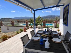 einen Tisch auf einer Terrasse mit Poolblick in der Unterkunft Finca rústica “Puerta Palo” in Alozaina