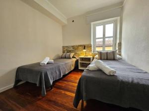 een kamer met 3 bedden en een raam bij 13A02 Céntrico 4 dormitorios in Ribadesella