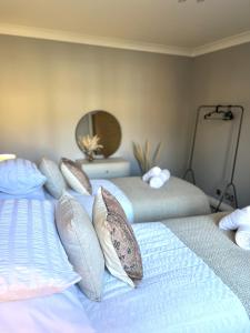 a bedroom with two beds with pillows and a mirror at Franklin Suite - Reading City Centre - Free Parking - Close to Station in Reading