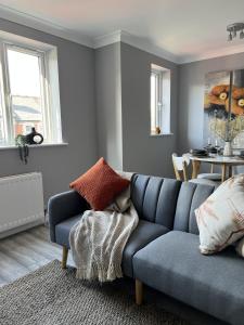 een woonkamer met een blauwe bank en een tafel bij Reading City Centre - Free Parking - Franklin Suite in Reading