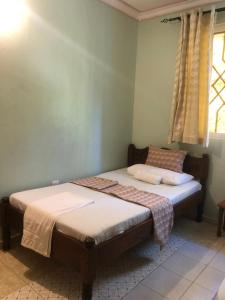 a bedroom with two beds and a window at Asali Nyali 2Br Peaceful Serviced Apartment Beach and Dining nearby in Mombasa