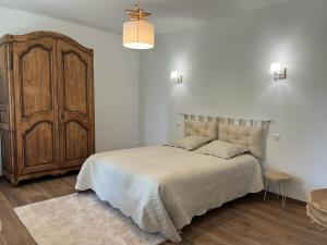 1 dormitorio con 1 cama grande y armario de madera en Le Domaine De Dolly, en Villeneuve-sur-Lot