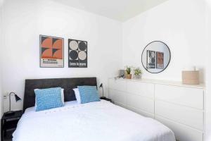 a bedroom with a bed with blue pillows and a mirror at Ambassador apartment+parking in Tel Aviv