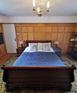 a bedroom with a bed with a blue comforter and two lamps at Canalside Cottage in Barton under Needwood