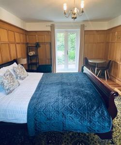 um quarto com uma cama com um edredão azul e uma janela em Canalside Cottage em Barton under Needwood