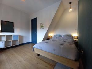 una camera con un grande letto e una TV di Maison familiale de charme au coeur de Rosendael a Dunkerque