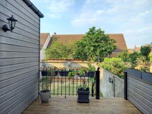 een patio met een hek en 2 potplanten bij Maison familiale de charme au coeur de Rosendael in Duinkerke